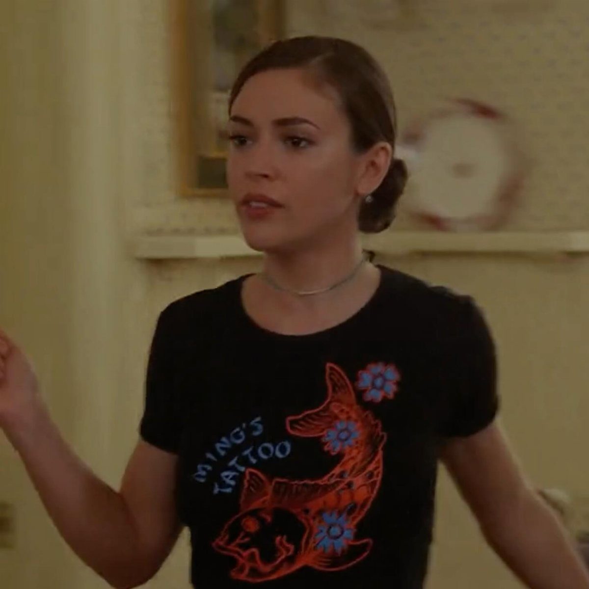 Woman wearing a black graphic t-shirt with an orange fish design.