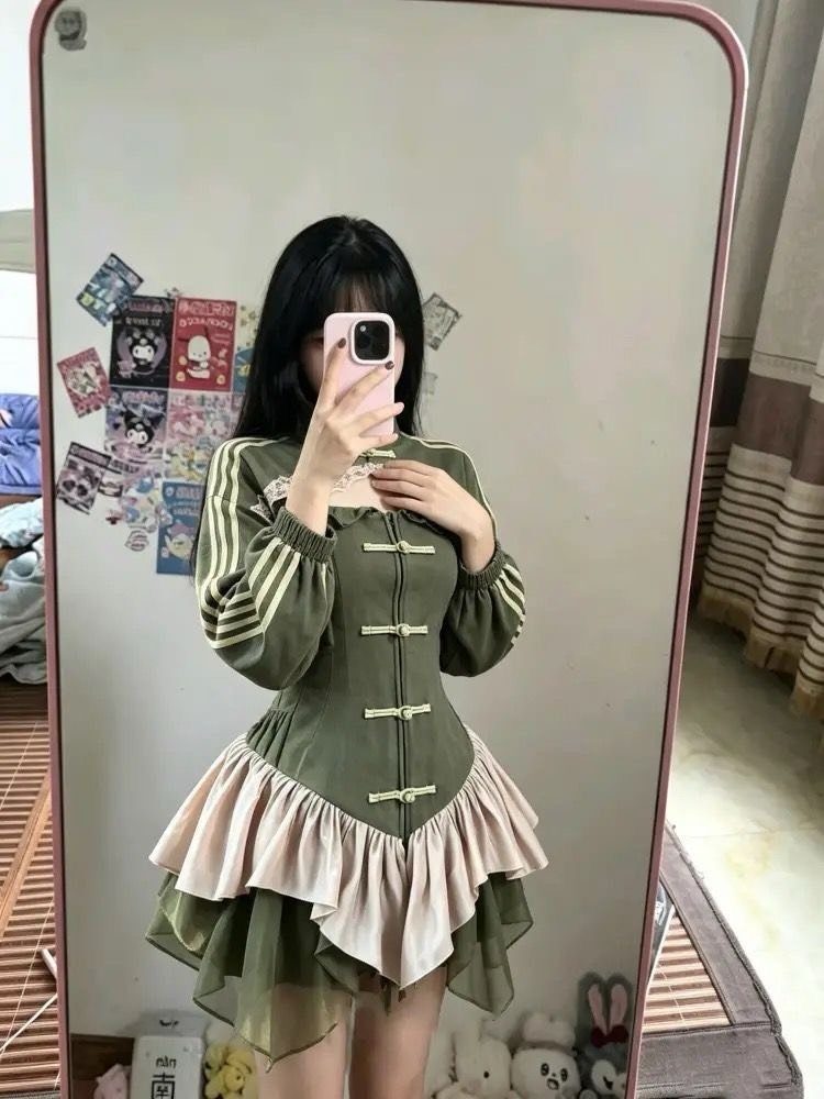 Woman in a green Chinese style dress with white stripes and ruffled skirt.