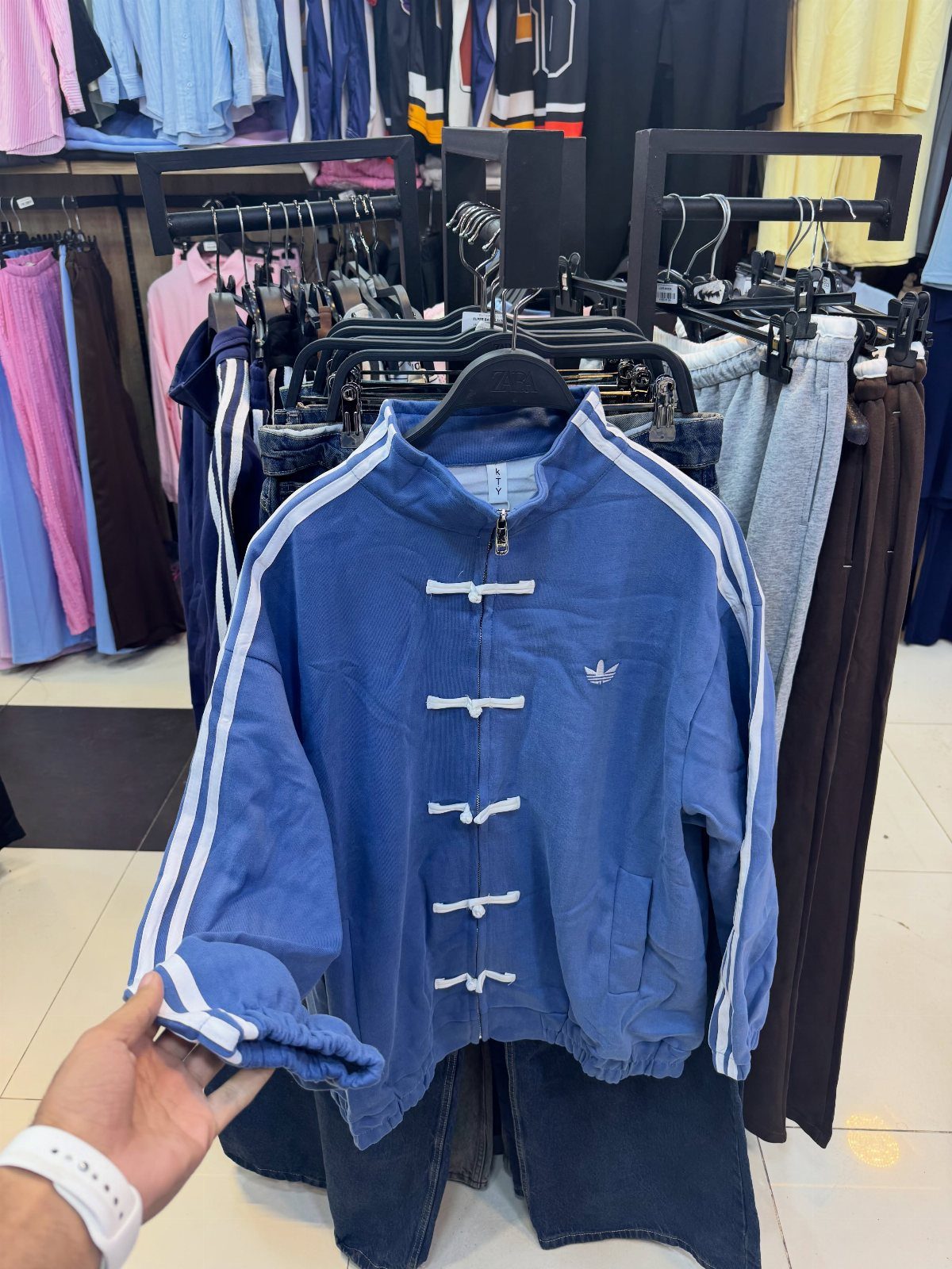 Blue Adidas jacket with traditional Chinese frog buttons and white sleeve stripes.