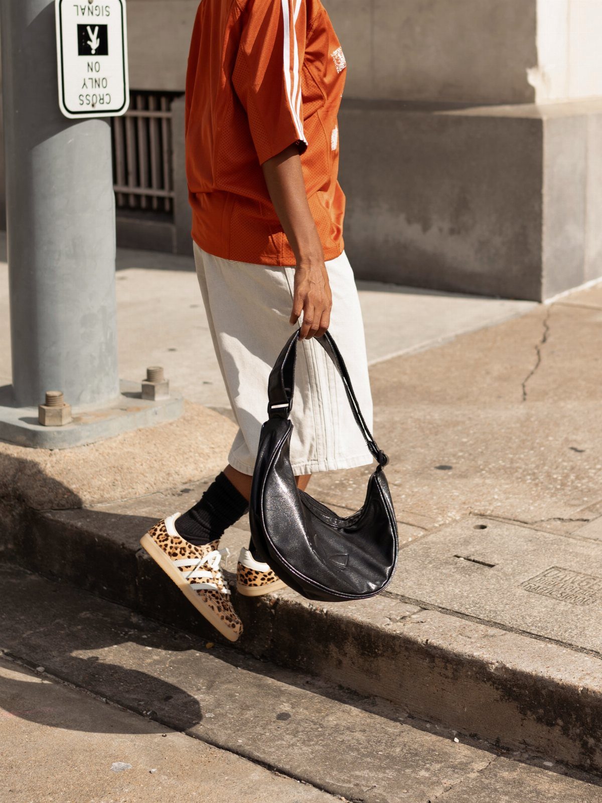 Leopard print Adidas Samba sneakers worn with white shorts and black socks.