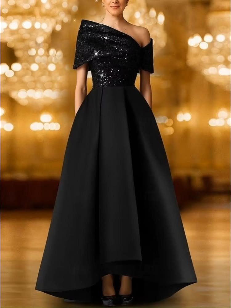 Person in a black gown with sequined bodice and full floor-length skirt.