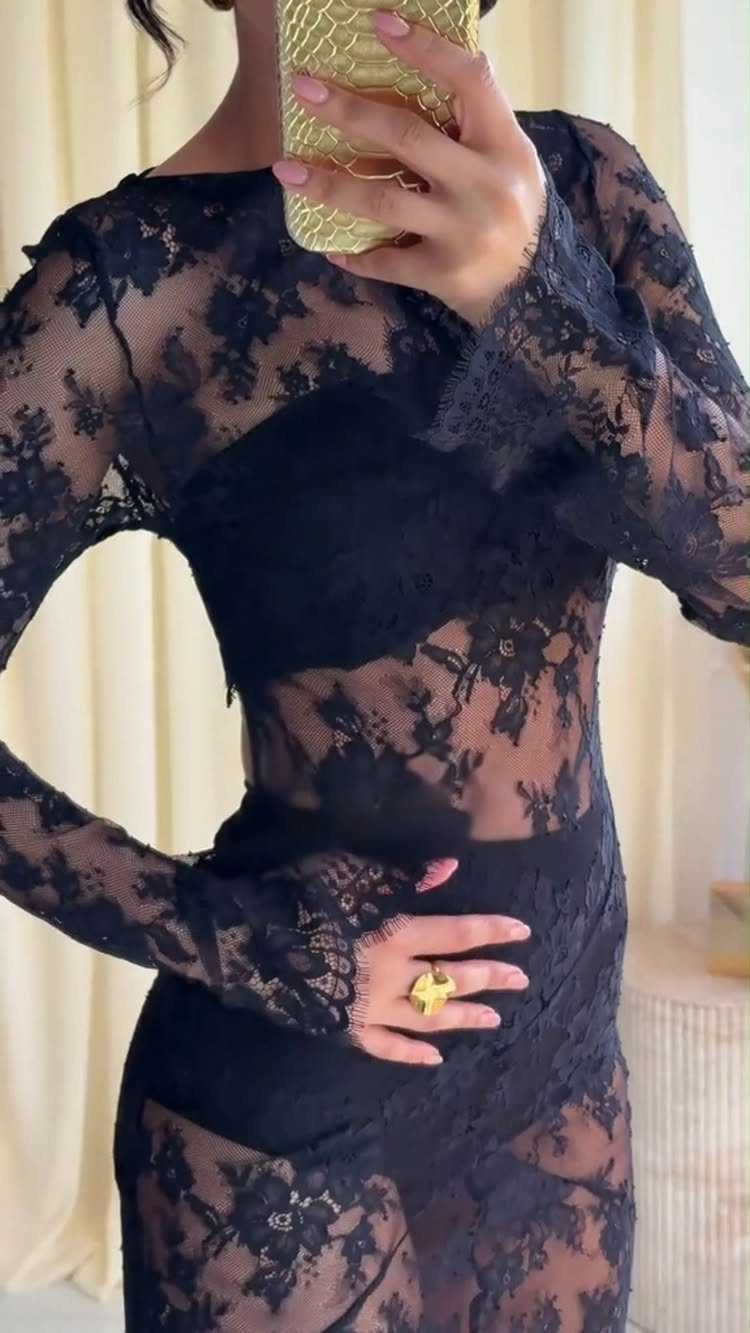 Person wearing a sheer black lace long-sleeve top and matching lace skirt.