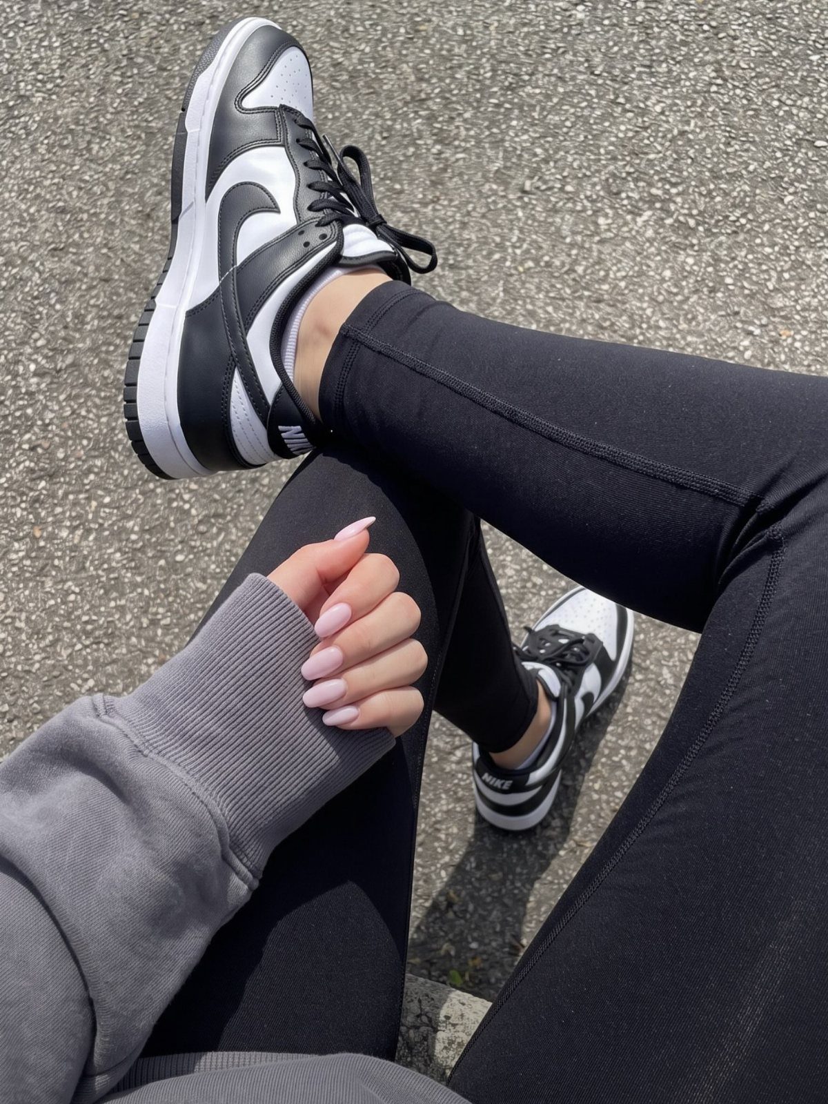 Black and white Nike sneakers worn by a person in black leggings.