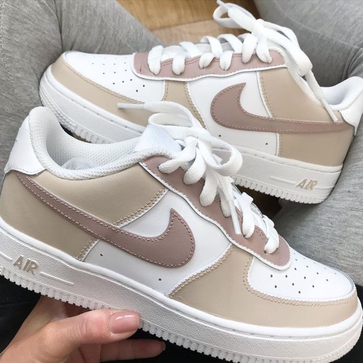 Nike sneakers in white, beige, and tan leather with white laces and soles.