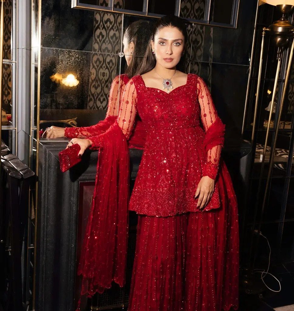 8 Beaded Formal Dress Ideas for Every Color and Style 2 Woman in a red beaded formal tunic and trousers standing by a mirror.