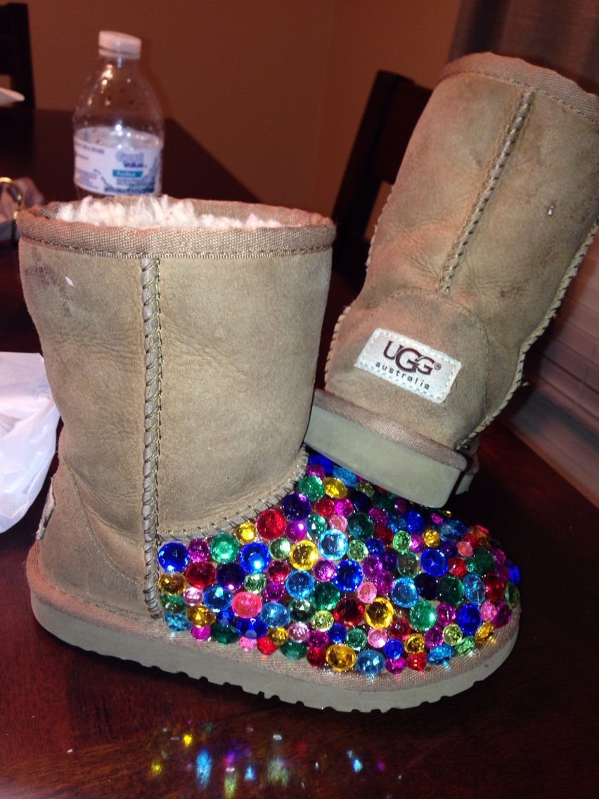 Tan suede UGG boots with multi-colored rhinestones covering the toe area.