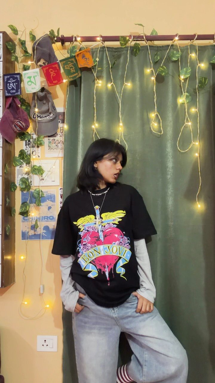 Person wearing a black Bon Jovi graphic t-shirt and light-wash wide-leg jeans.