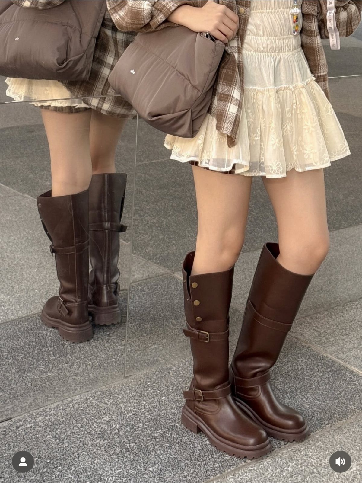 Brown leather mid-calf boots with buckles worn with a white lace skirt.