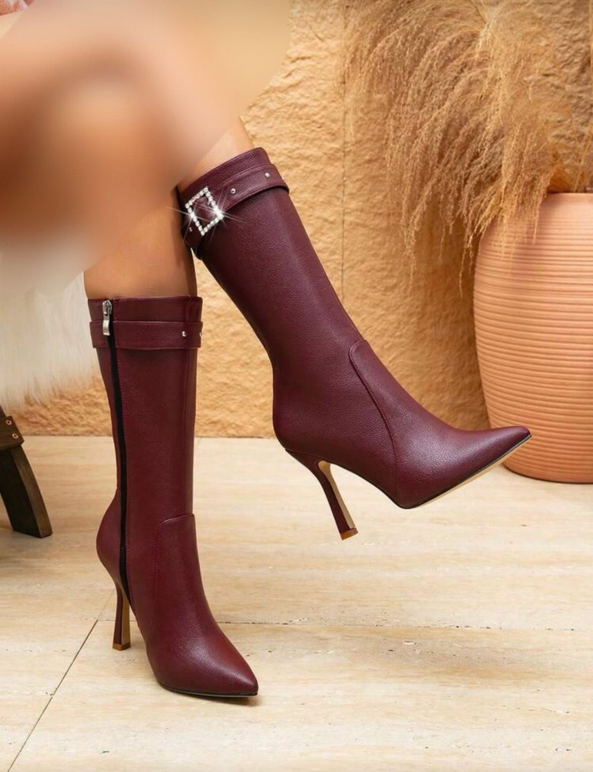Burgundy mid-calf boots with pointed toes, stiletto heels, and a silver buckle strap.