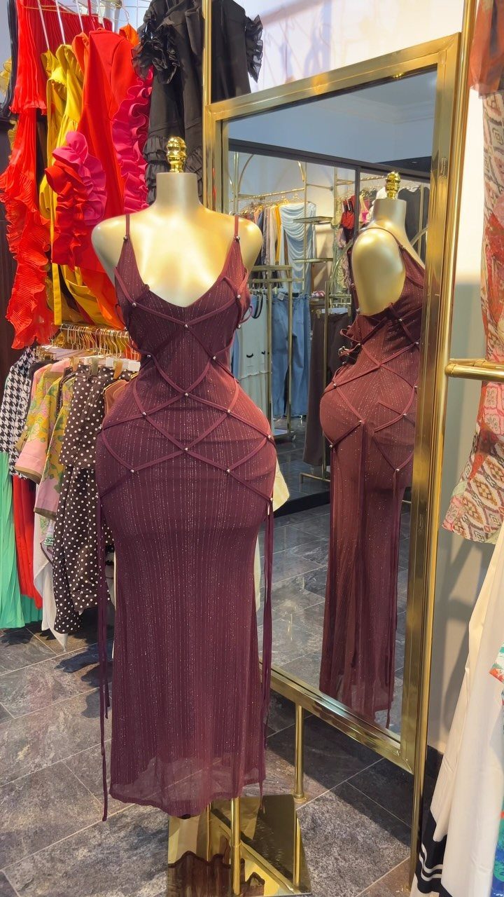Burgundy glittery midi dress with cutout details displayed on a mannequin in store