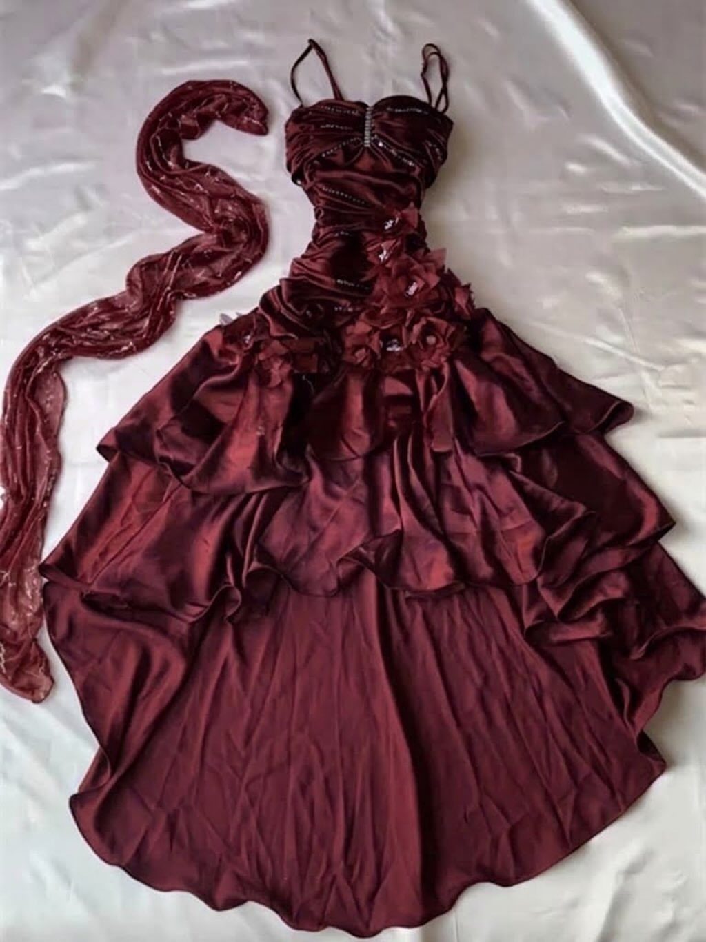 Burgundy satin high-low dress with ruffles and matching shawl on white fabric