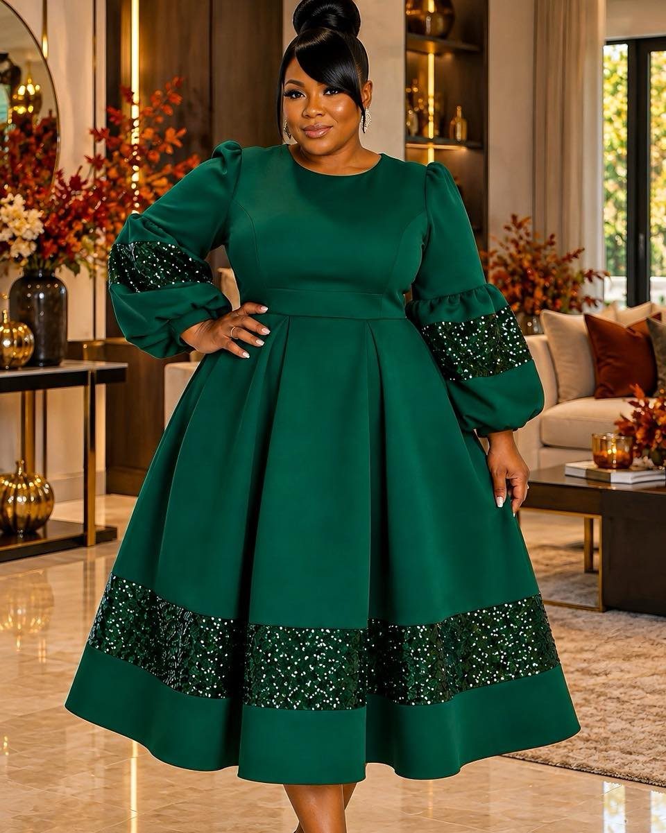 Woman in a dark green sequined A-line dress posing in a modern living room