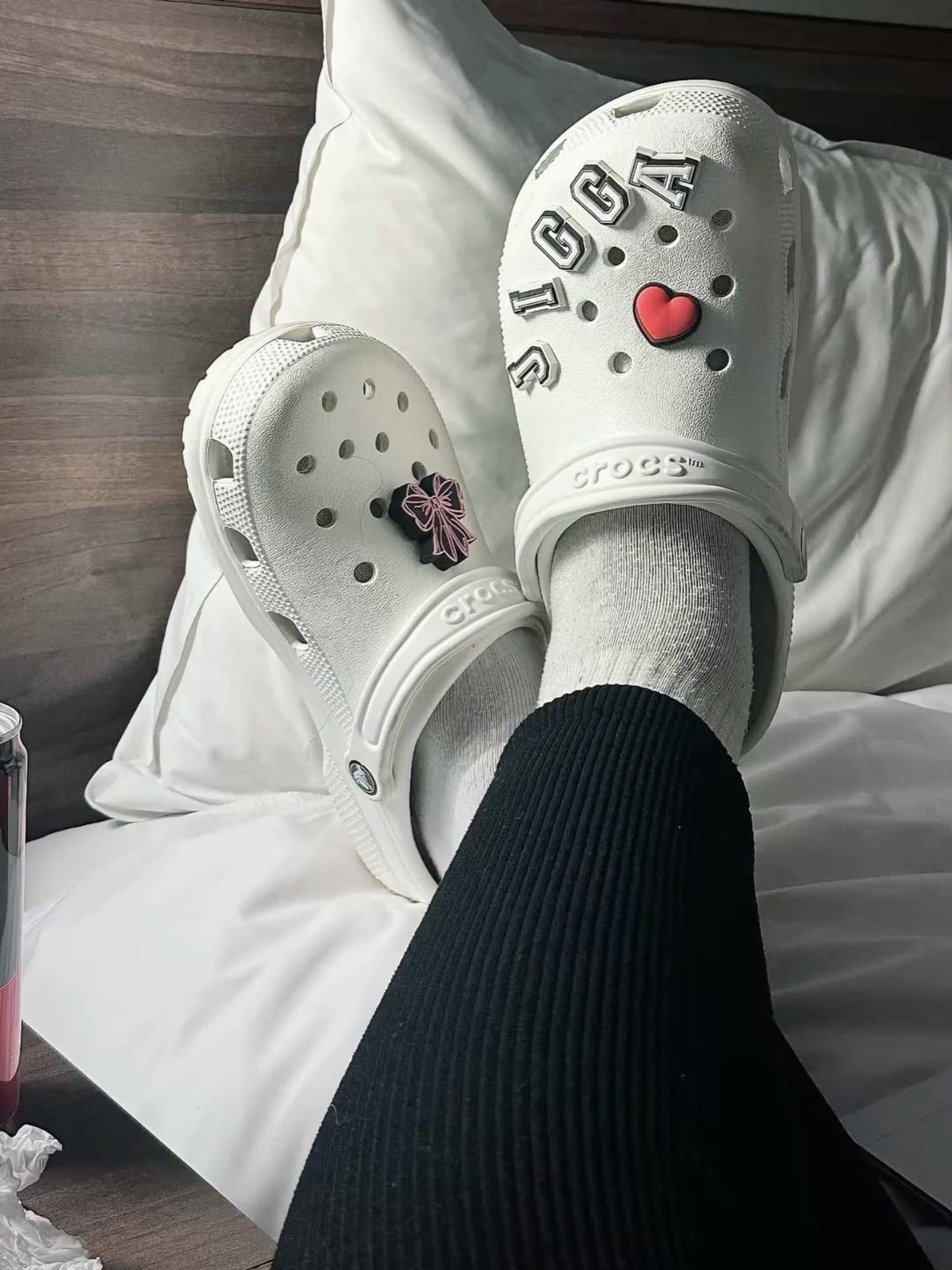 White Crocs clogs with heart and letter charms worn with white socks.