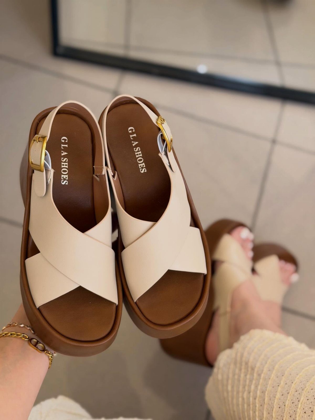 Clothing and Shoes: 8 Ideas for Everyday Outfits 6 Beige platform sandals with criss-cross straps held up against a tiled floor.