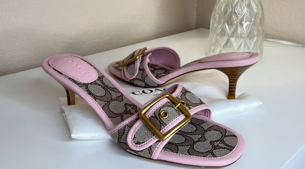 Pink patterned canvas sandals with gold-tone buckles and kitten heels on white surface