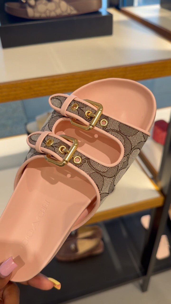 Pink Coach Signature Gwen slide sandals with double straps and gold buckles.