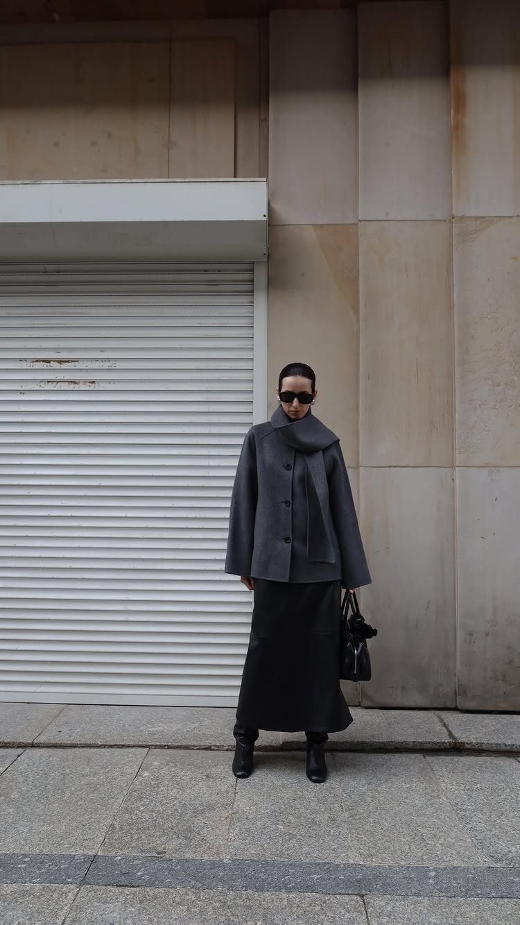 9 Dress and Coat Outfit Ideas for Work, Evenings and More 9 Woman wearing a grey oversized coat and long black dress with black boots.