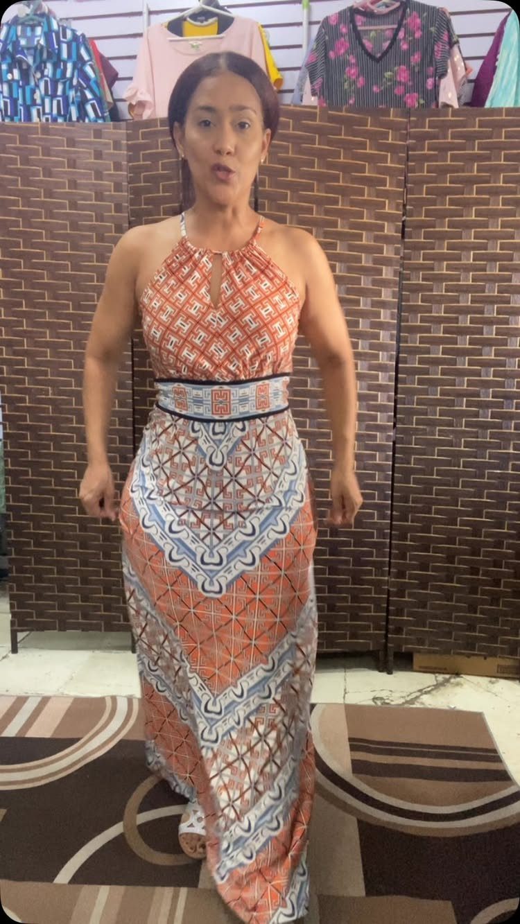 Woman wearing an orange and blue patterned halter style maxi dress with keyhole neckline