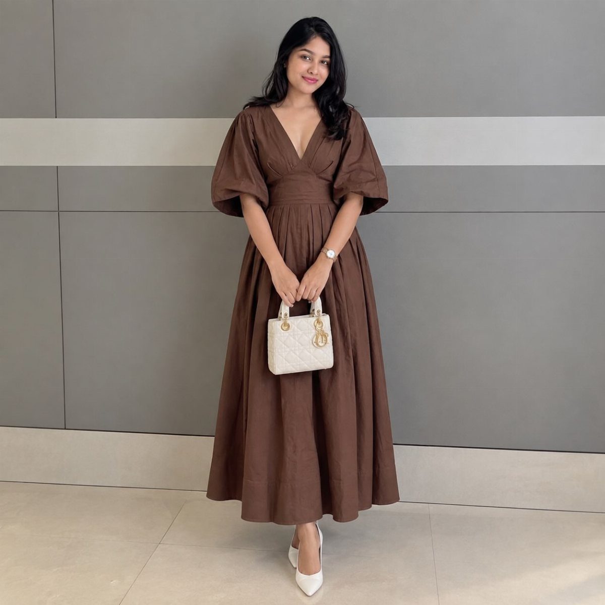 Woman in a brown V-neck dress with puffed sleeves and a voluminous skirt.