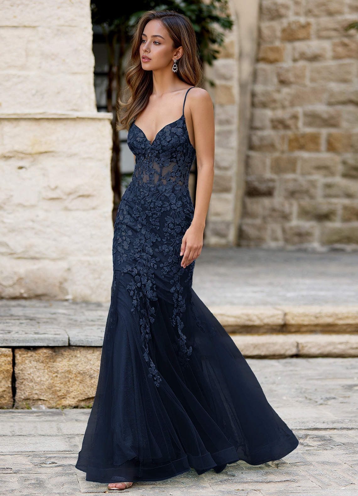Woman in a navy blue mermaid dress with lace and a flared skirt.