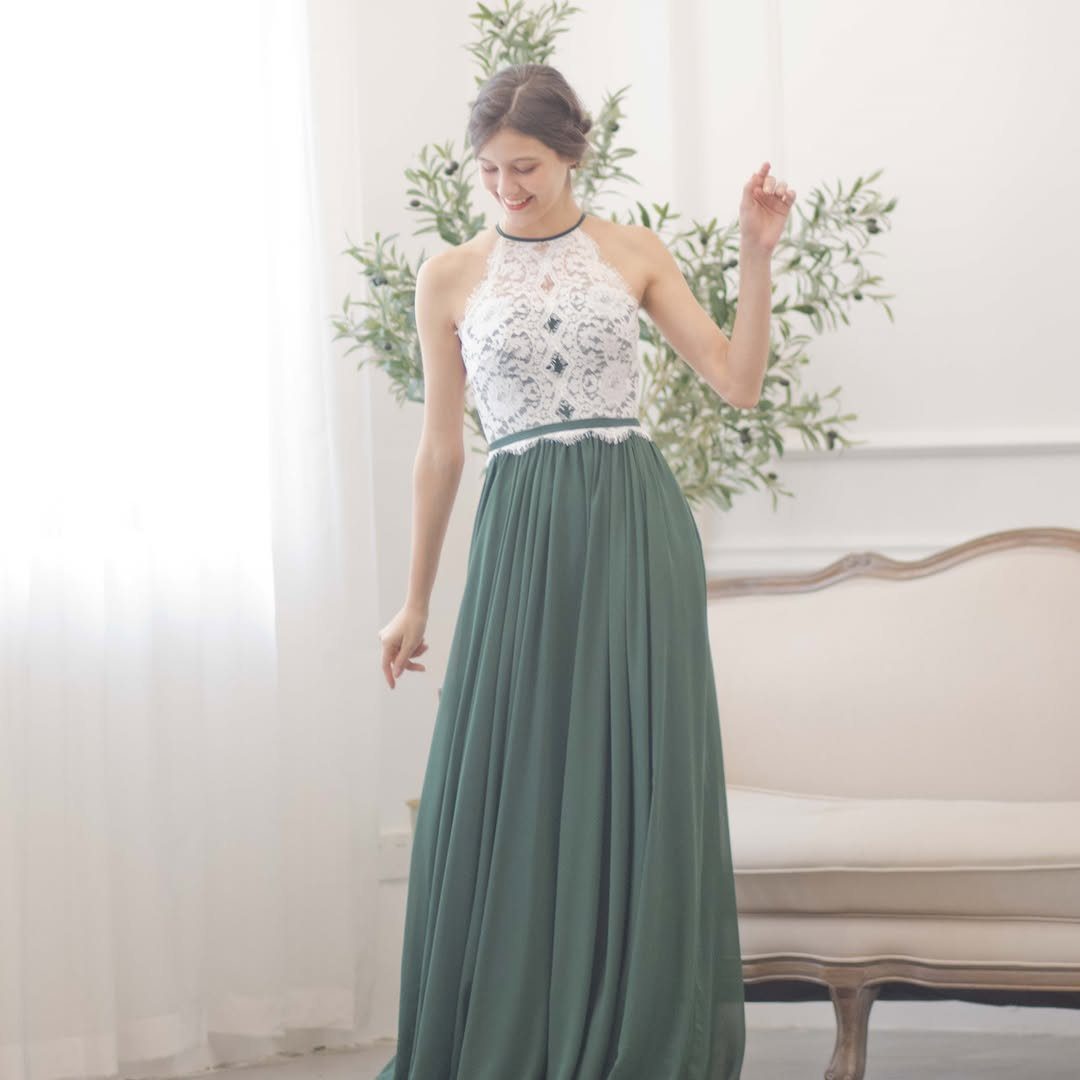 Woman wearing a white lace and sage green chiffon bridesmaid dress in a bright room