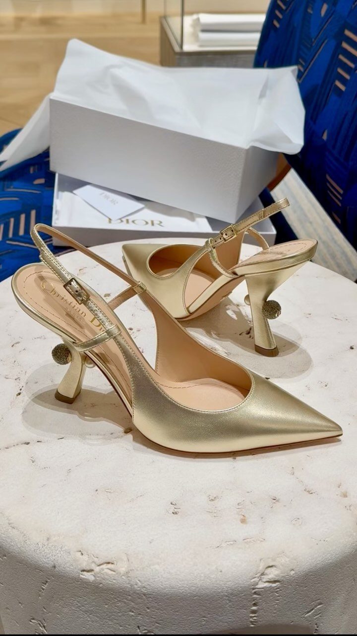 High Heels Design Ideas: 9 Styles from Slingbacks to Platforms 1 Gold pointed-toe slingback high heels on a white stone table with Dior packaging.