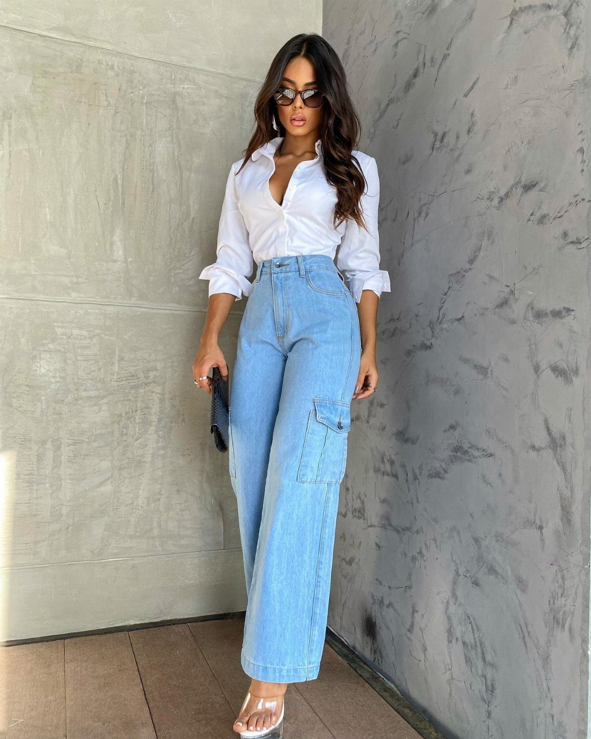 Woman in white button-down shirt and light blue high-waisted baggy cargo jeans.