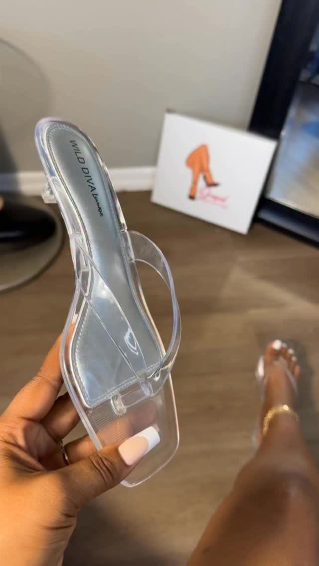 Clear PVC jelly kitten heel sandal with a low block heel held by hand.