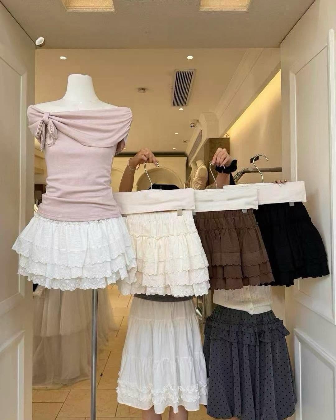 Tiered ruffled mini skirt sets in various colors displayed on a mannequin and hangers.