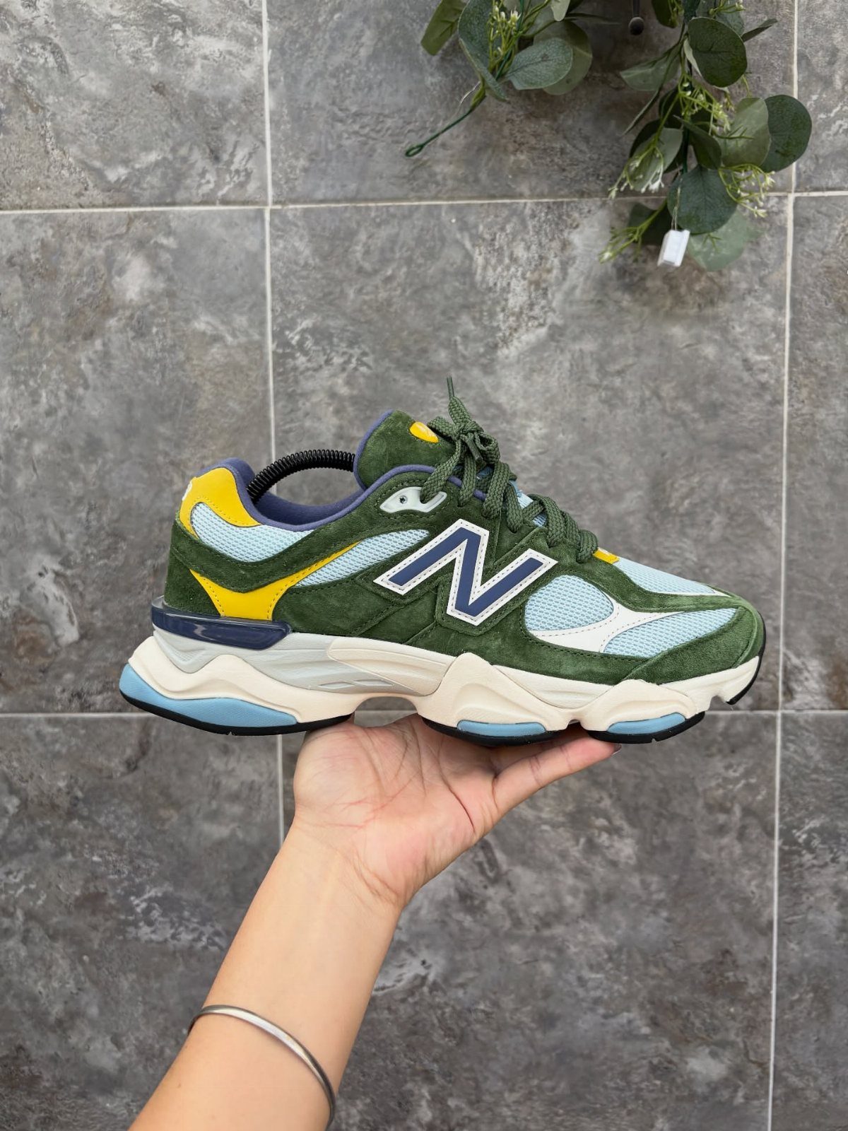 New Balance 9060 All Colors: 8 Pairs to Consider 2 New Balance 9060 sneaker in dark alpine green and yellow held by hand.