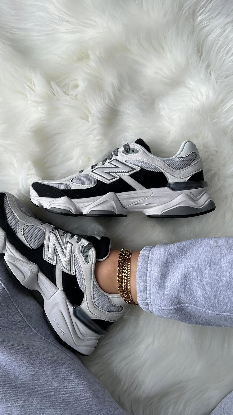 New Balance 9060 sneakers with sculpted soles on a white faux-fur rug.