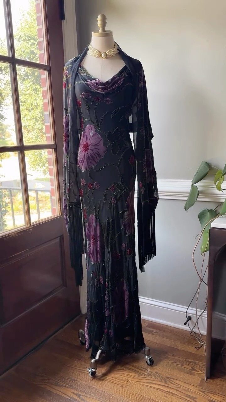 Black vintage dress with purple floral embroidery and fringe on a mannequin