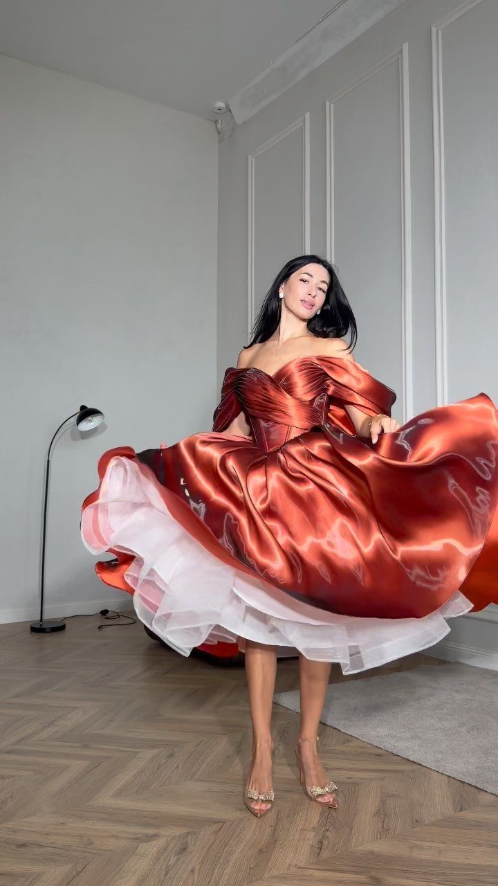 Woman in a shimmering copper satin off-the-shoulder cocktail dress with a full skirt.