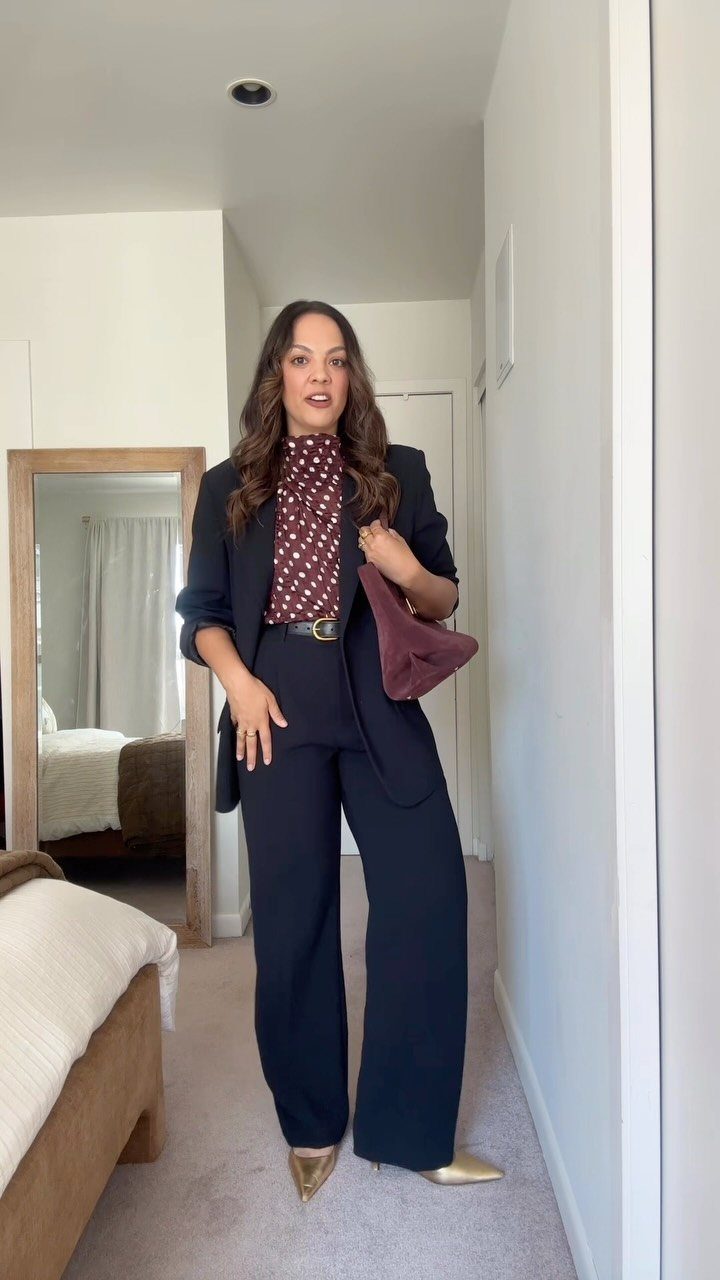 Woman wearing a navy blue suit and polka dot blouse for a job interview.
