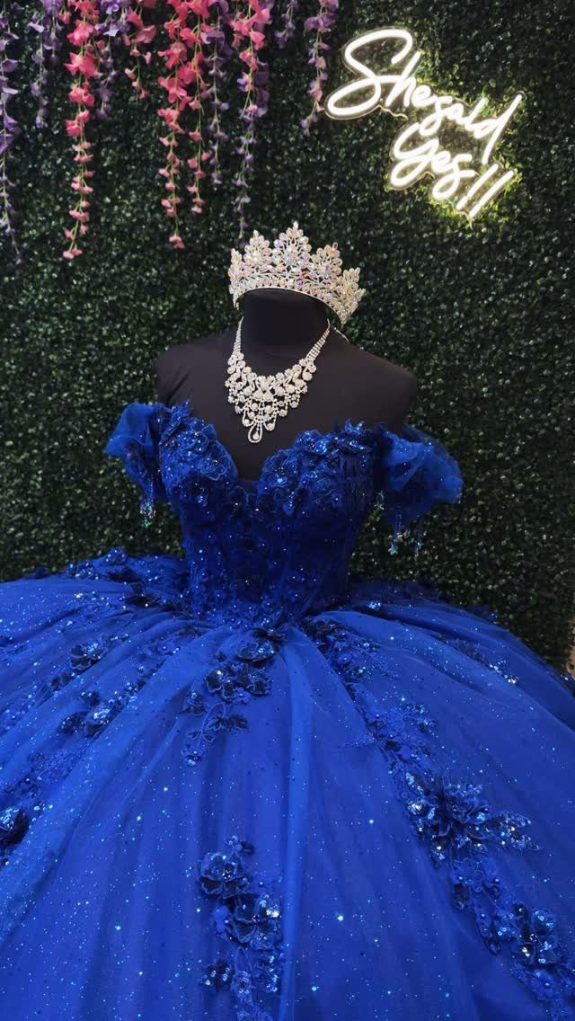 Royal blue ball gown with sequins on a mannequin wearing a crown.