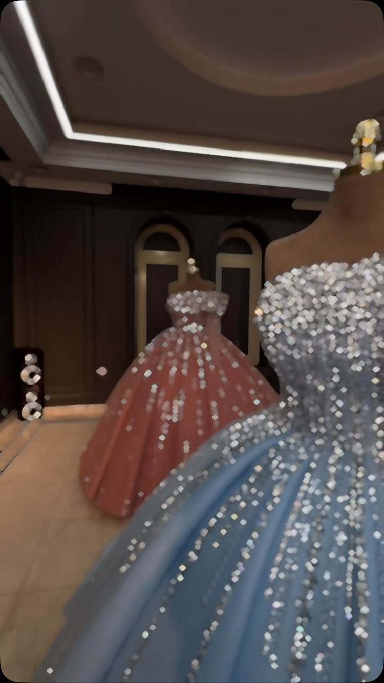 Two shimmering sequined ball gowns in blue and peach displayed on mannequins.