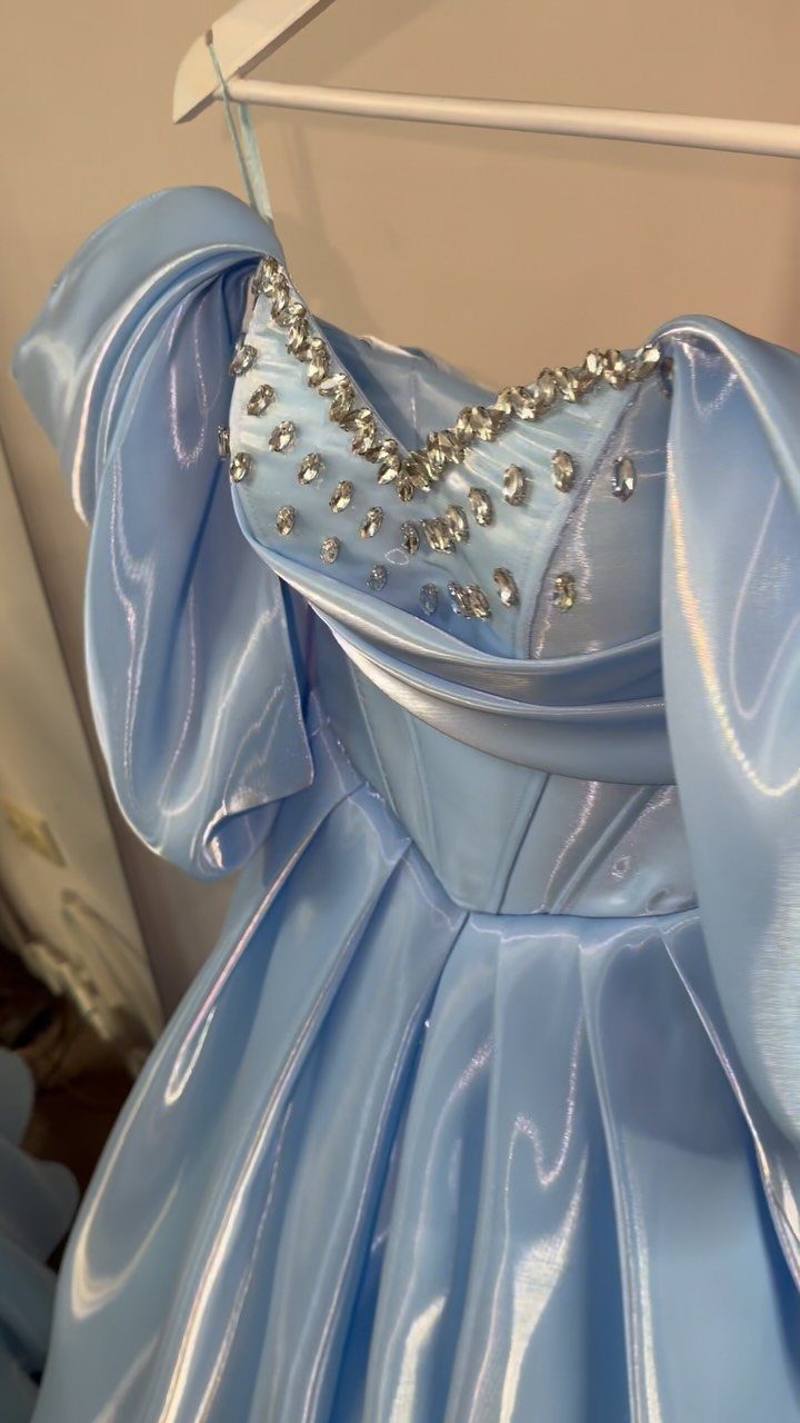 Light blue satin ball gown with a crystal-embellished sweetheart neckline on a hanger