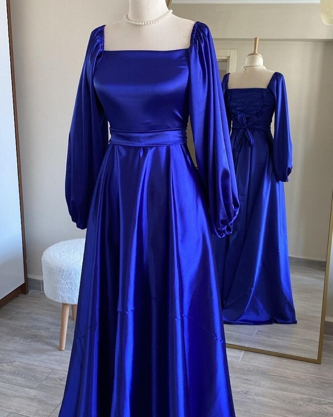 Royal blue satin gown with square neckline and puff sleeves on a mannequin