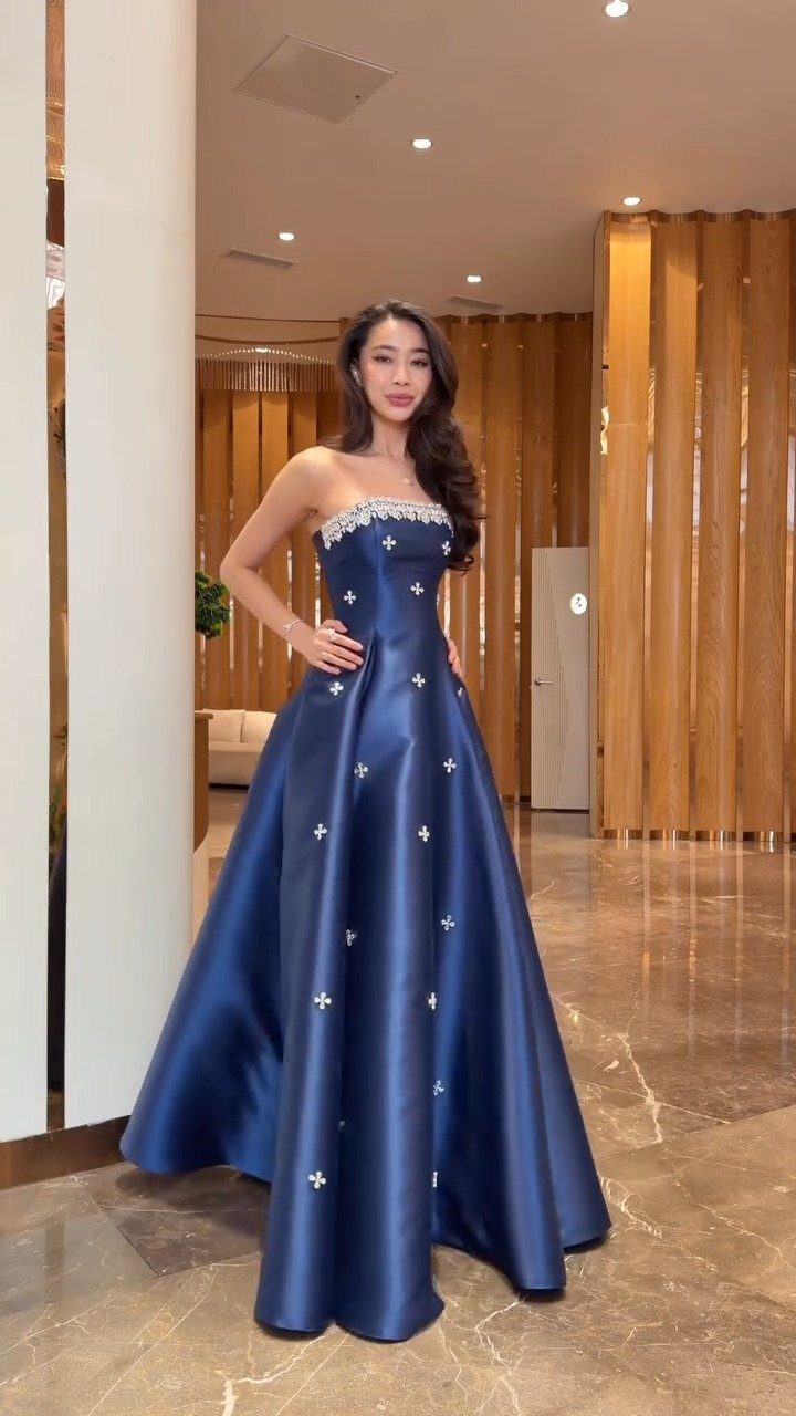 Woman in a strapless royal blue satin gown with a full flared skirt