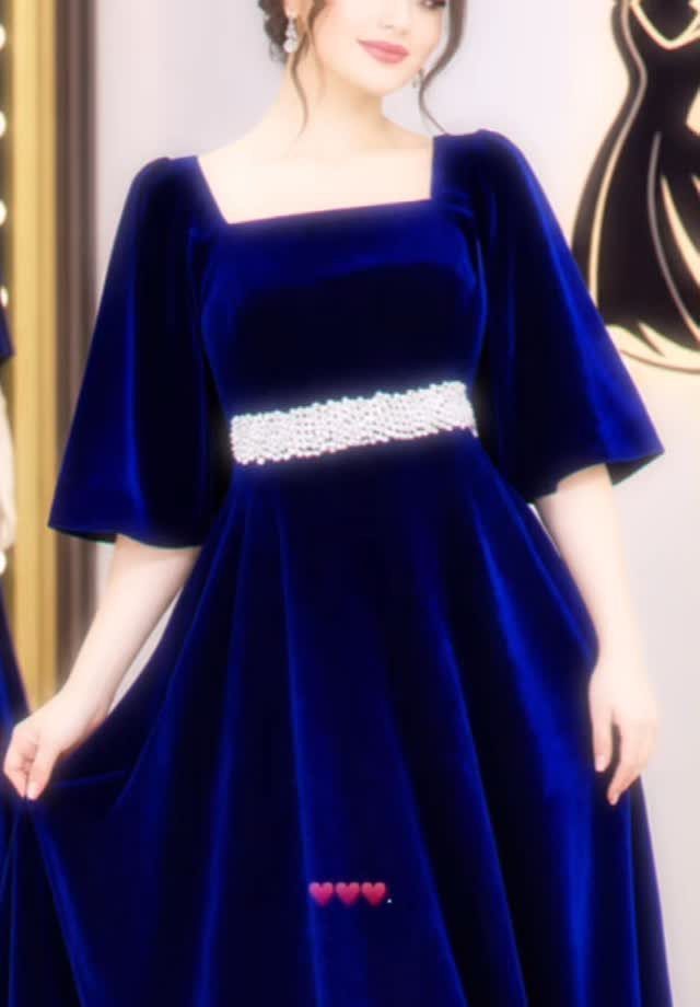 Woman wearing a royal blue velvet gown with a silver beaded waist belt.