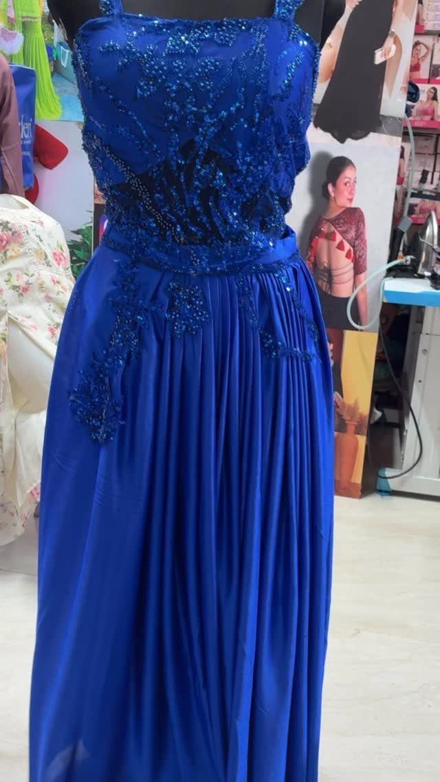 Royal blue gown with sequined bodice and pleated skirt on a mannequin