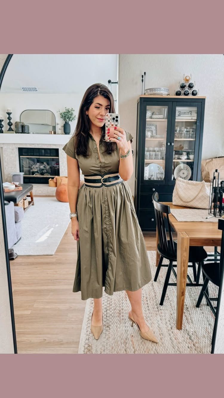 Woman in olive green midi dress with black belt and beige heels.