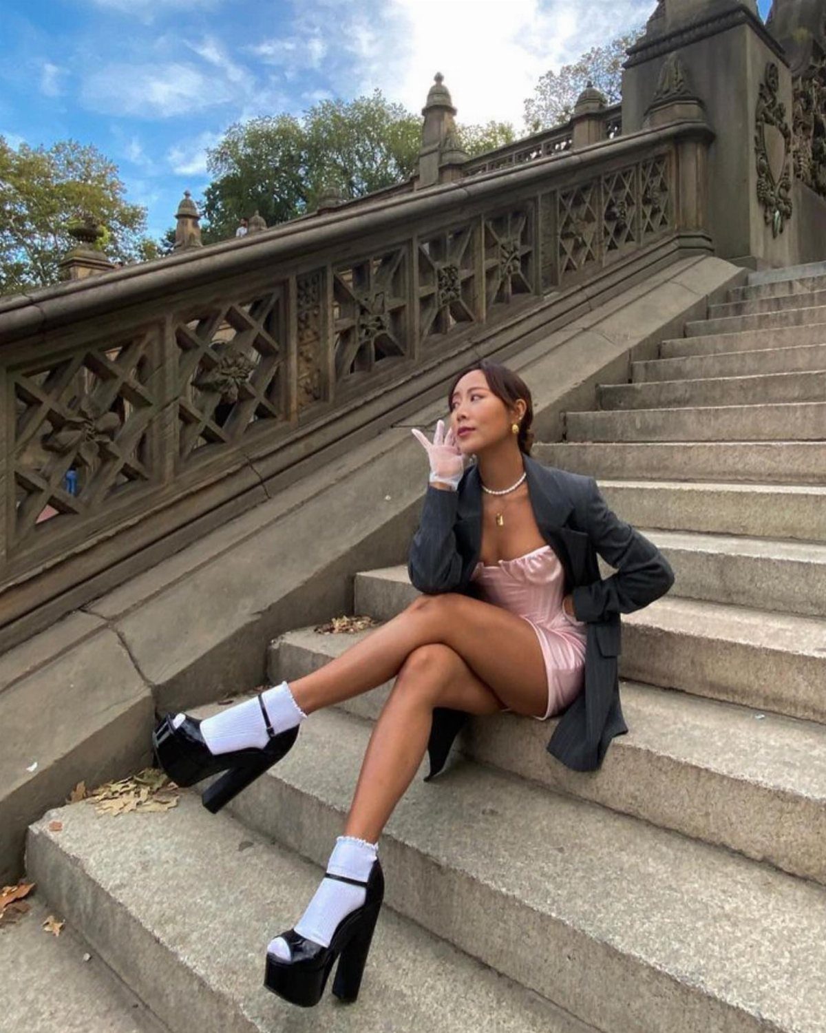 Woman in pink dress and grey blazer wearing white socks with black platform pumps