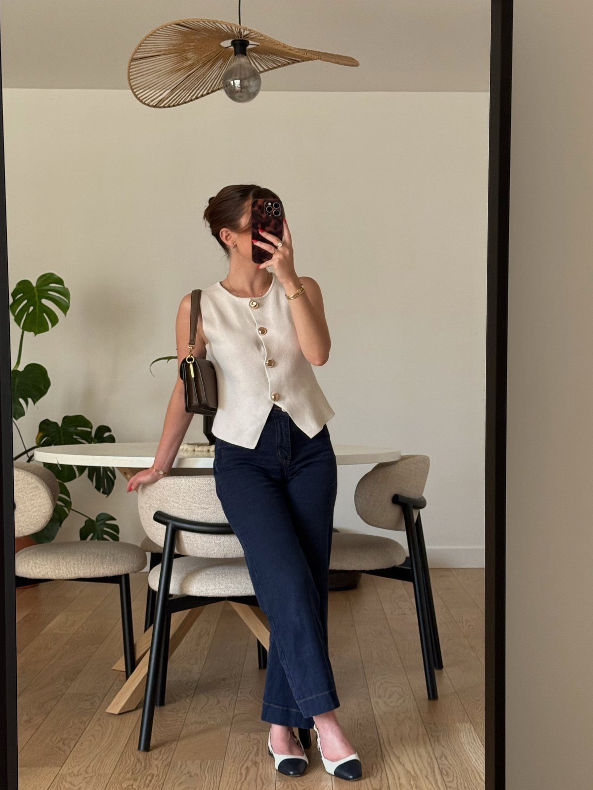 Woman wearing a white sleeveless vest and navy trousers for a professional look.