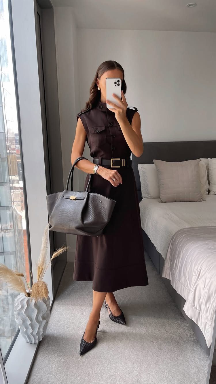 Woman in a dark brown midi shirtdress with a black belt and heels.