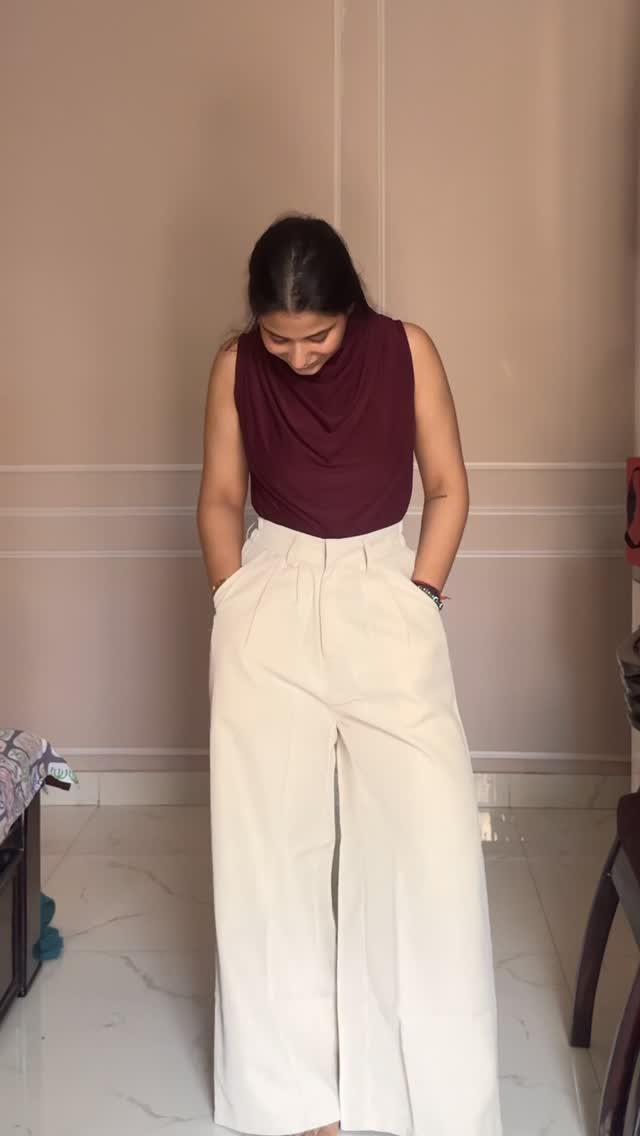 9 Summer Wide Leg Pants Outfit Ideas for Easy Style 1 Woman wearing a maroon sleeveless top and high-waisted beige wide leg trousers.