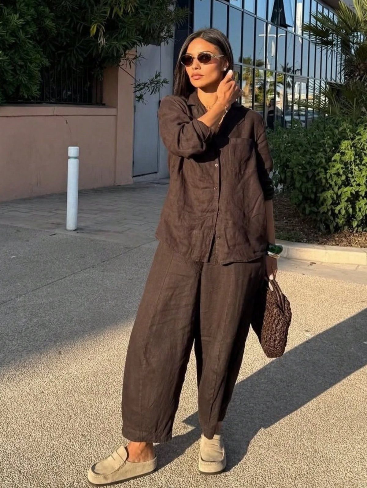 9 Summer Wide Leg Pants Outfit Ideas for Easy Style 3 Woman wearing a matching dark brown linen shirt and wide leg pants set.