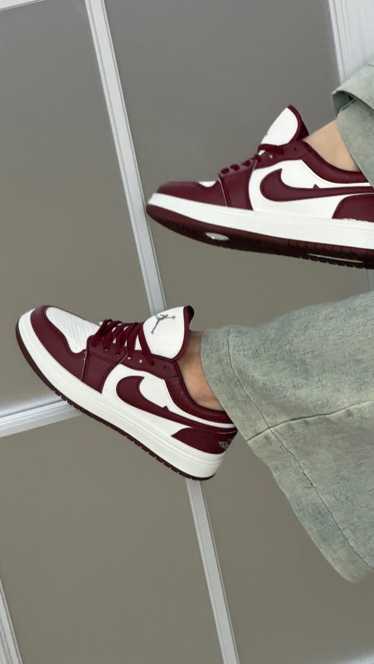 Burgundy and white leather high-top sneakers worn with light green trousers.
