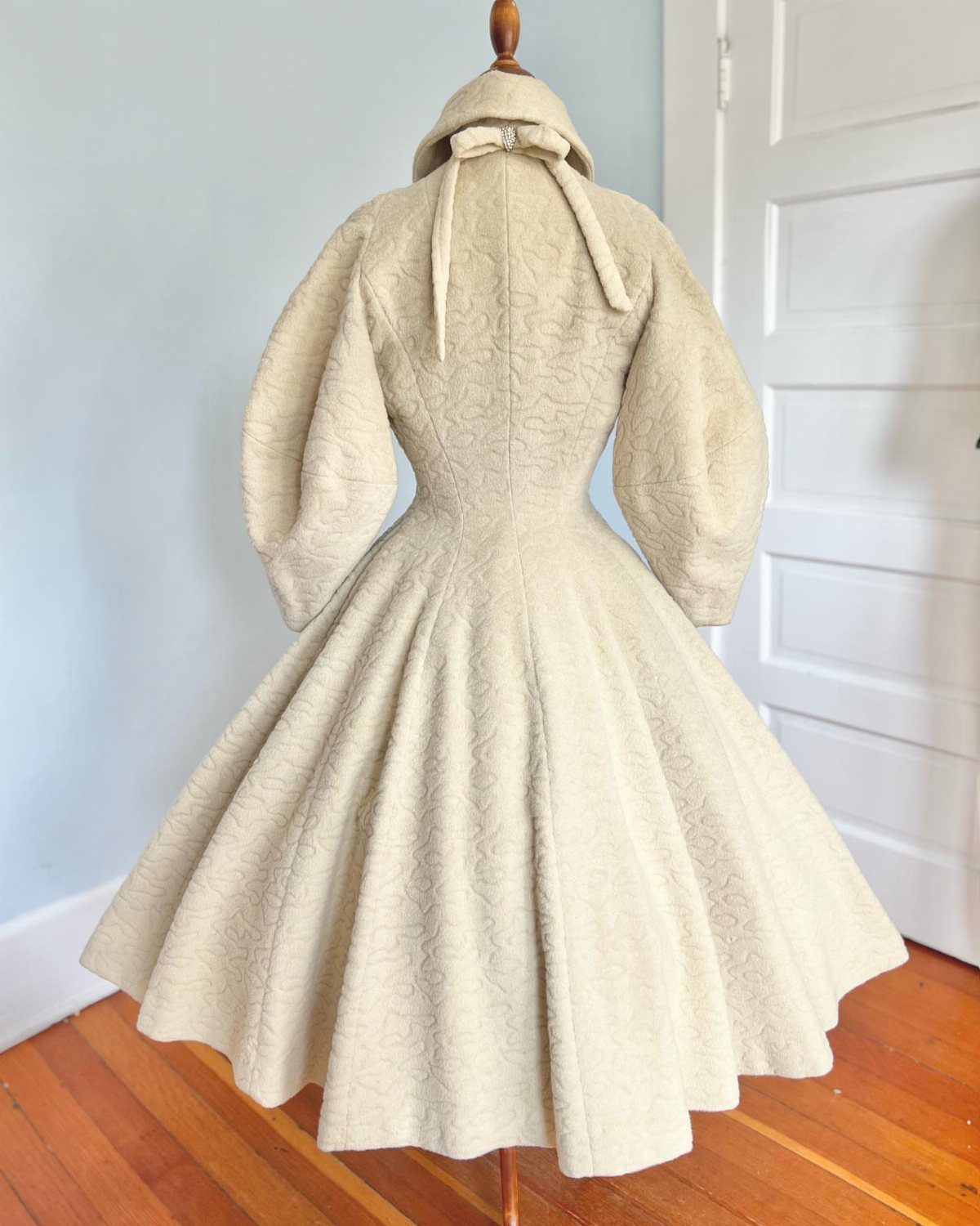 Cream vintage dress with puff sleeves and full skirt on a mannequin.