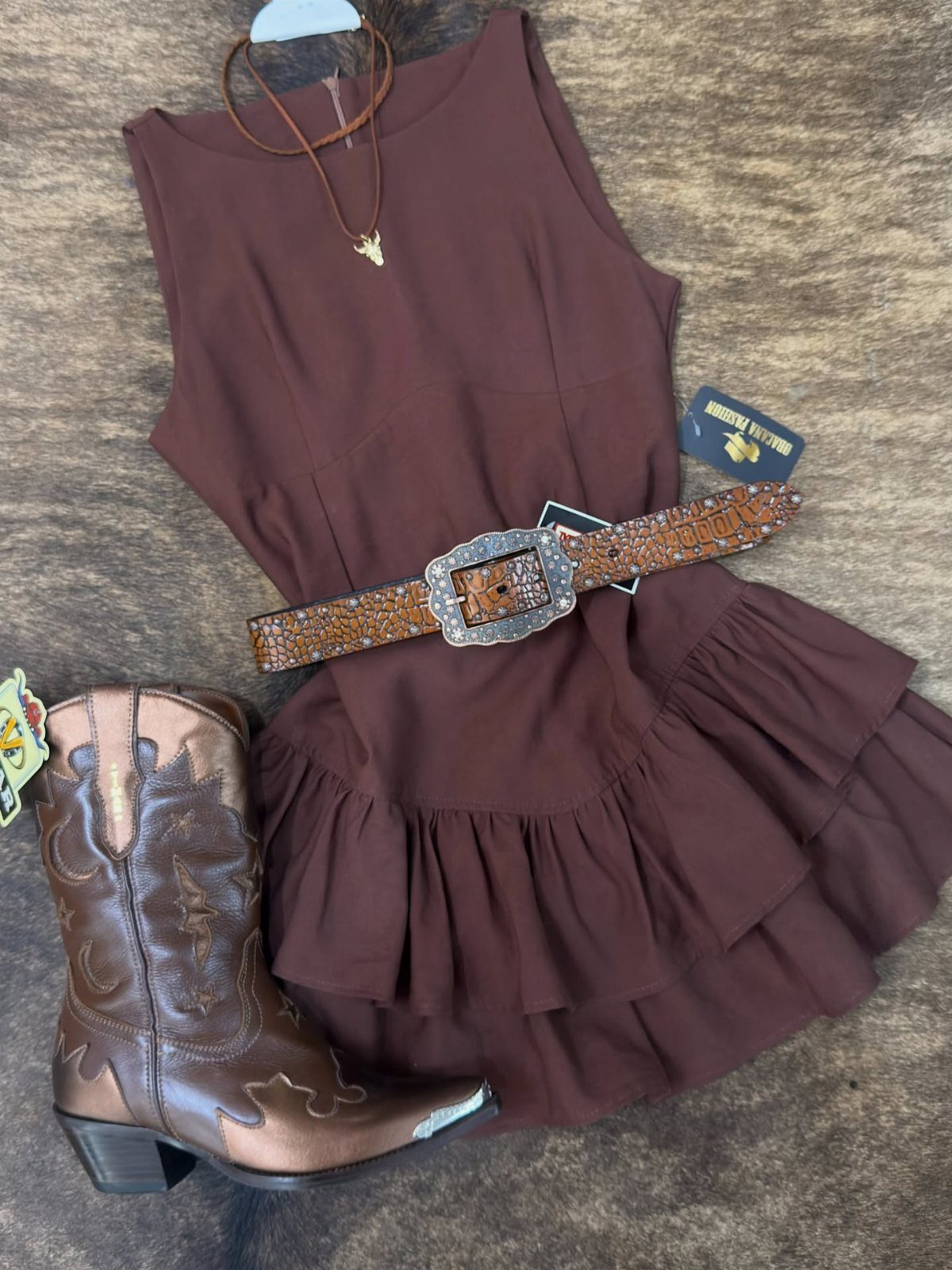 Western Themed Party Outfit Ideas: 8 Looks to Wear 8 Brown ruffle dress with cowboy boots and a large buckled belt on textured background